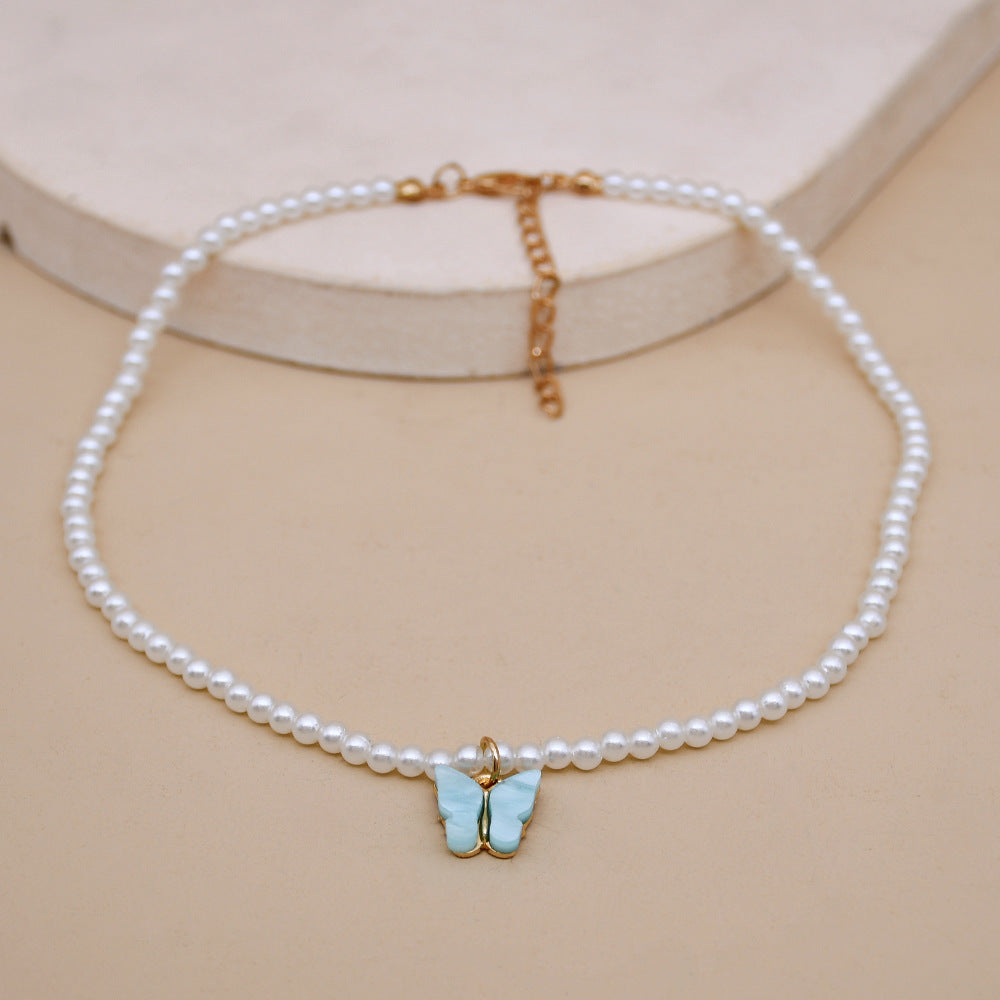 Collier raffiné en perles et papillon délicat