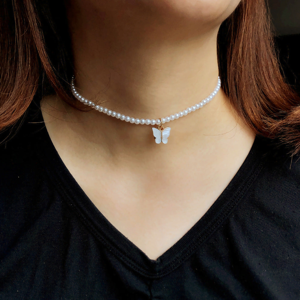 Collier raffiné en perles et papillon délicat