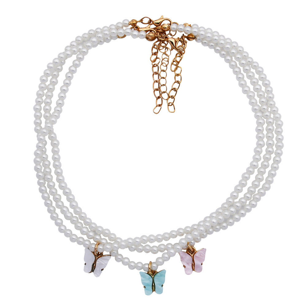 Collier raffiné en perles et papillon délicat