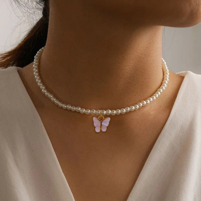 Collier raffiné en perles et papillon délicat