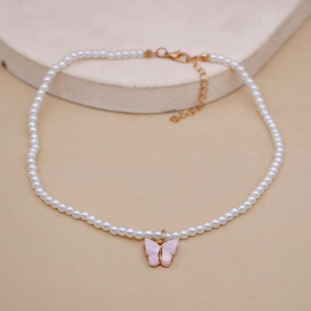 Collier raffiné en perles et papillon délicat