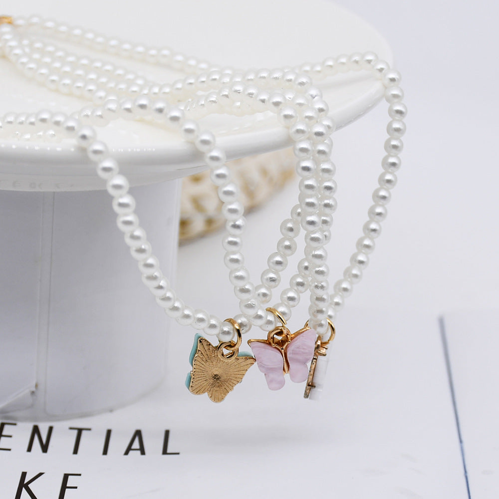 Collier raffiné en perles et papillon délicat