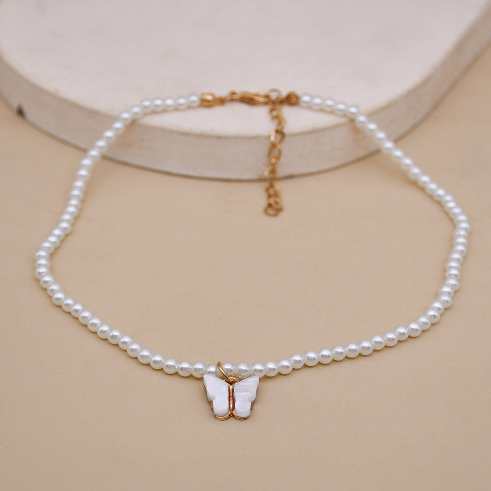 Collier raffiné en perles et papillon délicat