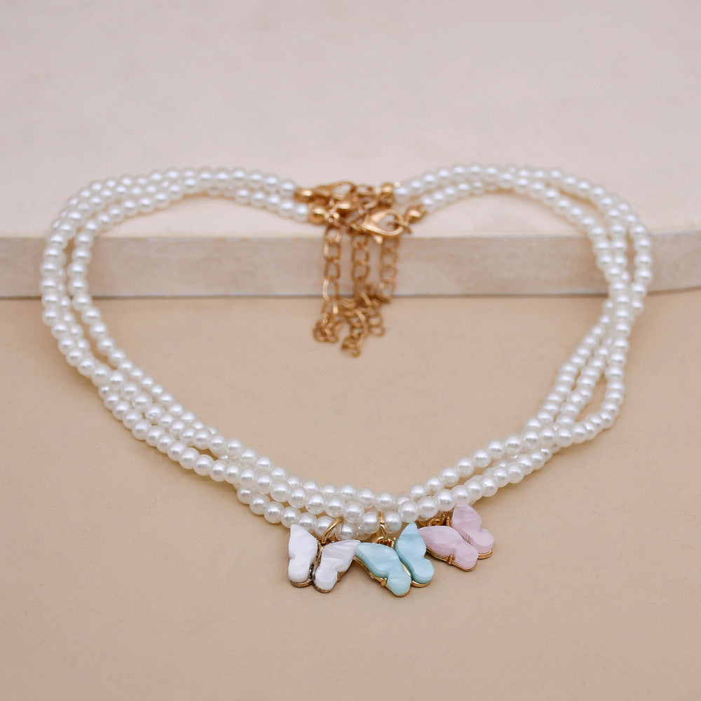 Collier raffiné en perles et papillon délicat